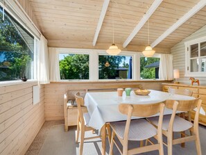 A wooden cabin interior with a dining table, chairs, and pendant lights. - "Wanna" - 600m from the sea by Interhome (Dannemare)