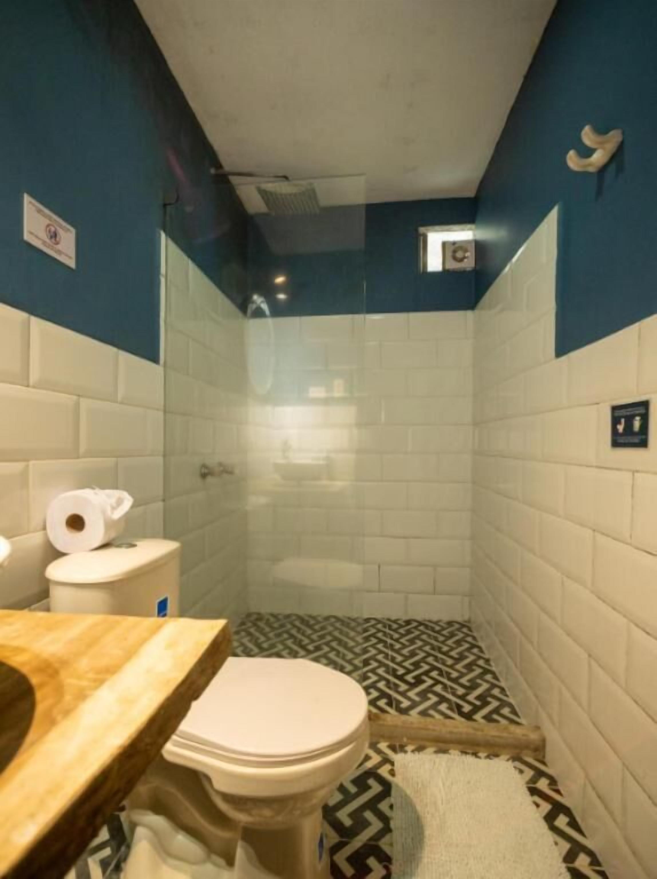 A small bathroom with a toilet, a sink, and a shower stall.