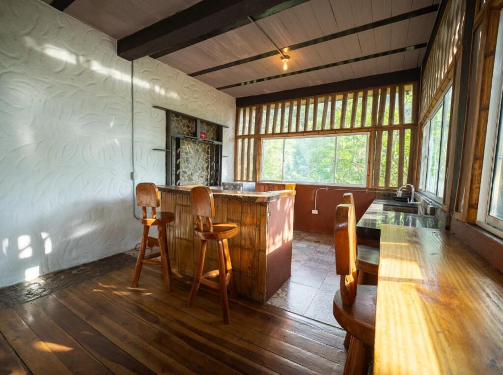 Ein Holzinterieur mit Barbereich, Holzstühlen und großen Fenstern.