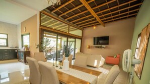 A dining area with a wooden table, chairs, and a television mounted on the wall.
