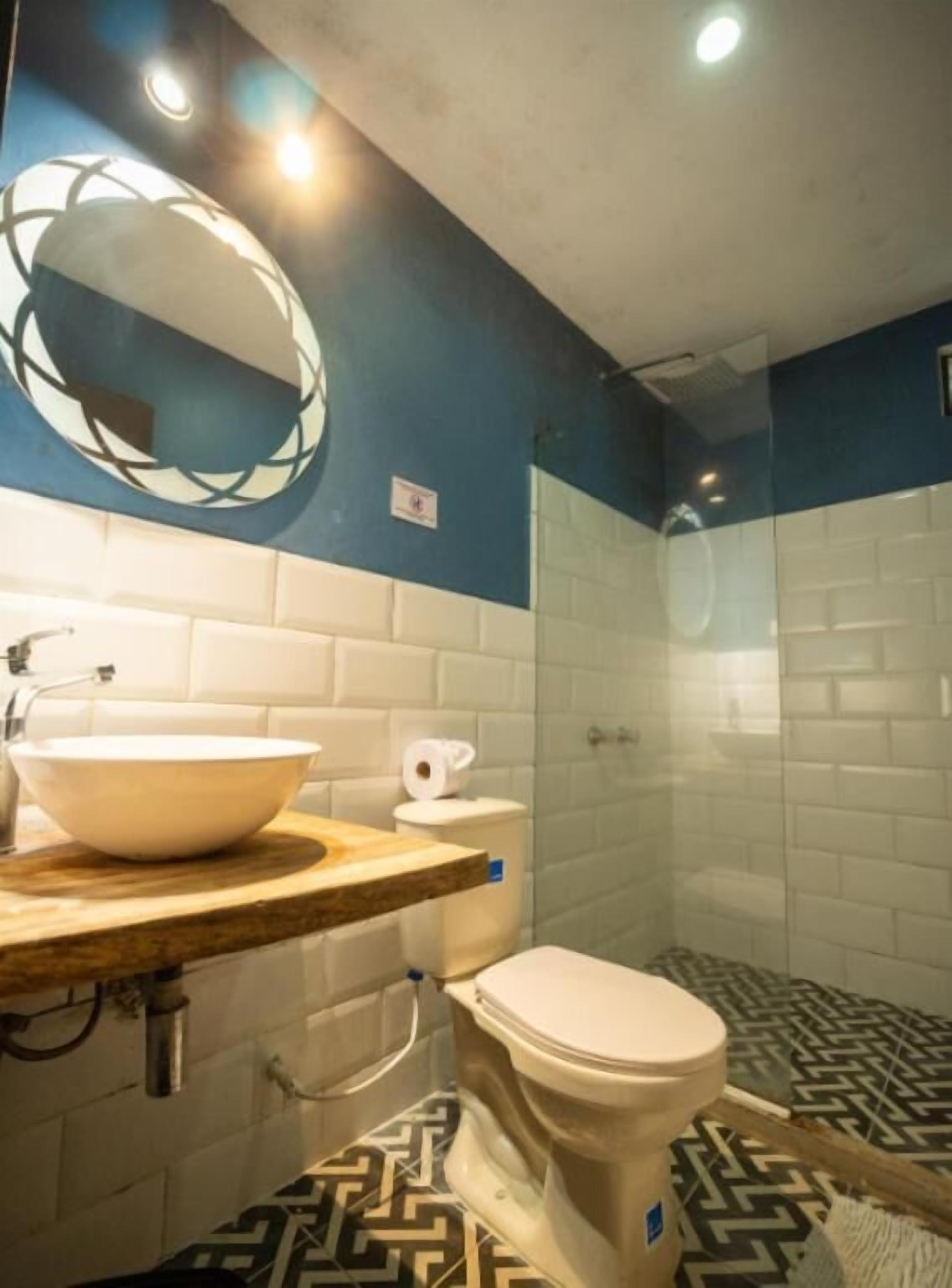 A bathroom with a white sink, toilet, and shower.