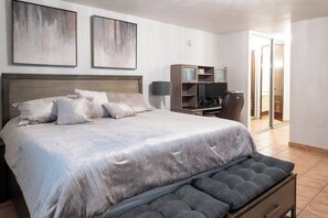 A bedroom with a large bed, a bench, a TV, and a wardrobe. - Oceanside Golf and Resort Villa in Dorado (Dorado)