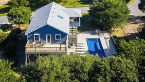 Un barrio residencial con casas, una piscina y vista al océano.