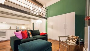 Un espacio moderno para vivir con sofá, una mesita y una zona de cocina.