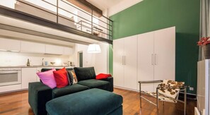 Ein modernes Wohnzimmer mit einer Couch, einem kleinen Tisch und einer Küchenzeile.