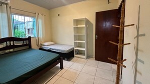 Un dormitorio con cama, armario, estantería y puerta.