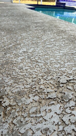 Primer plano de una superficie de concreto texturizada, probablemente parte de una zona junto a la piscina.