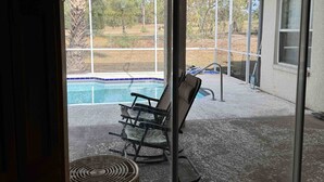 A covered patio with a pool, a ceiling fan, and outdoor furniture. - Spring Hill Gathering House (Spring Hill)