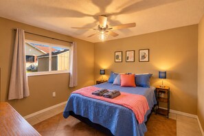 A bedroom with a bed, two bedside tables, a ceiling fan, and a window with curtains. - 4BR  Private Pool, Game Room & Sleeps 10 (Spring Hill)
