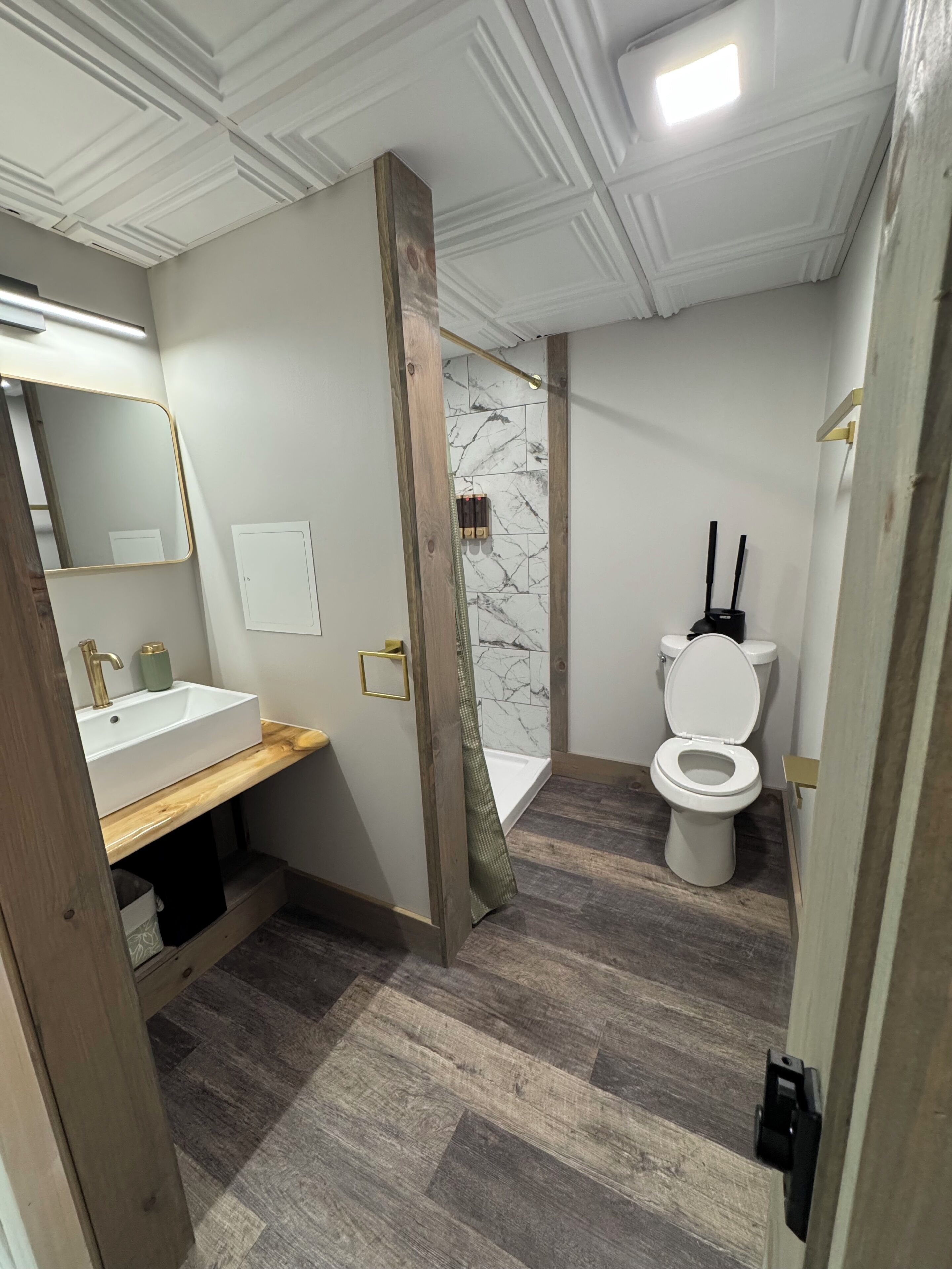 Een badkamer met een witte wastafel, toilet en douche.