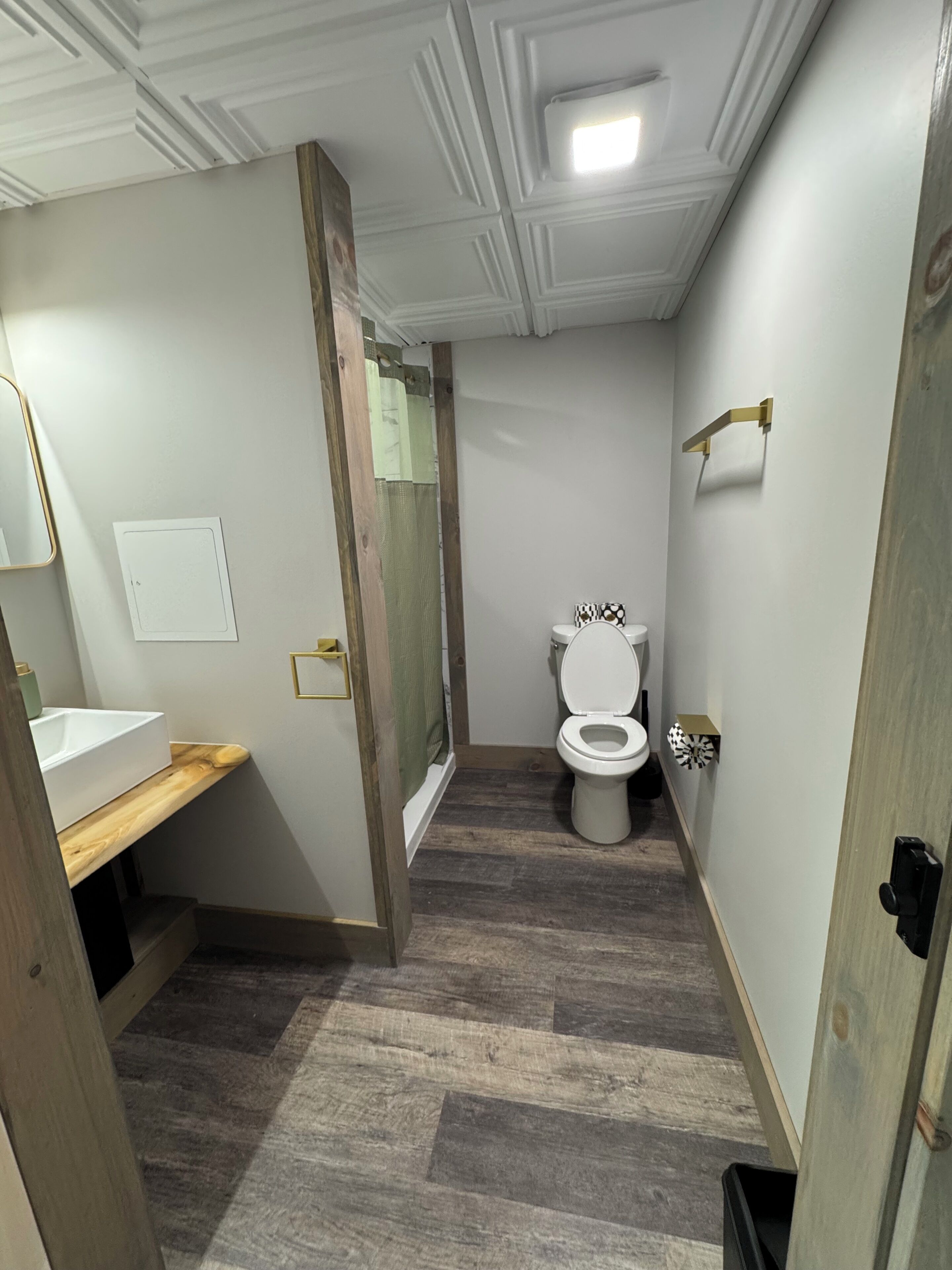 Un bagno con un mobile lavabo in legno, un water e una doccia.