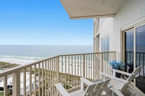 Ein Balkon mit Blick auf Strand und Meer.