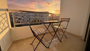 Un balcón con vistas a edificios y al atardecer.