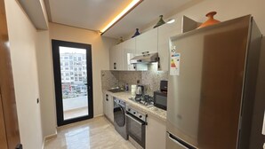 Una cocina moderna con electrodomésticos de acero inoxidable, encimera de granito y vistas de la ciudad a través de un amplio ventanal.