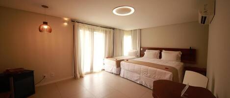 A hotel room with a bed, bedside tables, a desk, and a chair.
