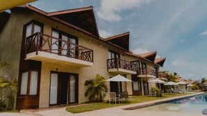 A hotel with multiple balconies, a swimming pool, and outdoor seating. - Pousada Rangai (Maragogi)