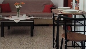 Un soggiorno con divano, tavolino, tavolo da pranzo, sedie e lampade a sospensione.