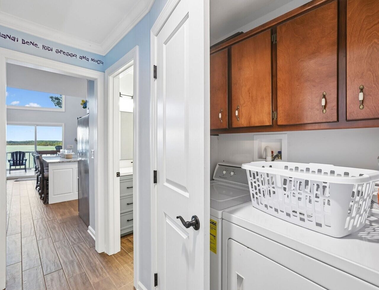 A kitchen with white cabinets, a stainless steel refrigerator, and a washing machine.