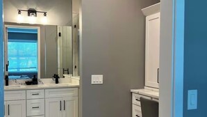 A bathroom with a white vanity, a mirror, and a shower area. - Family Friendly SWFL Home• 3BR, Sleeps 6, Screened Lanai (Fort Myers)