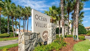 A sign for Ocean Villas with a stone base and a logo. - Ocean Views, Two Balconies, Easy Beach Access, Two Pools, 5 miles to Downtown, $300 in Free Tickets! (St. Augustine Beach)