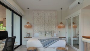 Quarto moderno com cama grande, duas mesas de cabeceira, escrivaninha e uma cadeira.