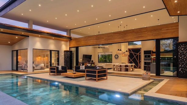 Uma casa moderna com piscina, área de estar externa e cozinha.