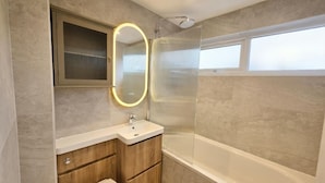 A modern bathroom with a bathtub, a toilet, a sink, and a shower with a glass door. - Modern 3BR Home - Super King, Office & Garden (Hemel Hempstead)