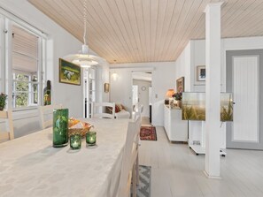 Ein modernes Interieur mit Essbereich, Küche und Wohnbereich.