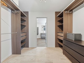 Un dressing avec des étagères en bois, un miroir et un petit coffre-fort.