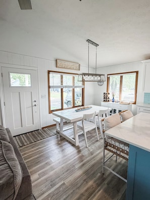 A modern kitchen with white cabinetry, a dining table, and a built-in island.