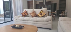 Ein Wohnzimmer mit einer Couch, einem Couchtisch und einem Essbereich mit Stühlen.