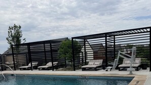 A swimming pool with lounge chairs and a pergola structure. - The Royal Retreat in enchanting Frisco (Frisco)