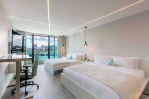 Habitación de hotel con dos camas, un escritorio y una silla.