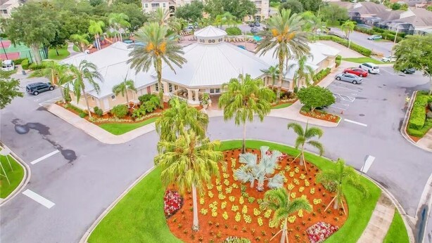 A residential area with a central building surrounded by palm trees and a parking lot. - Cozy 3-bedroom townhome with AC in perfect Kissimmee (Kissimmee)