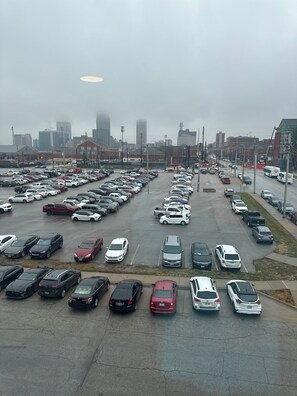 A large parking lot with multiple rows of parked cars and a city skyline in the background. - Bright apartment within walking distance of college World Series and downtown (Omaha)