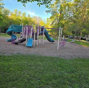 A playground with a slide, climbing structures, and a swing set.