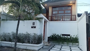 A villa with a balcony, a white exterior, and a sign indicating it is DWhite Beach Villa.