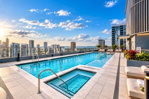 A rooftop pool with a city view, lounge chairs, and a clear sky. - LUXURY 1BR/1BA DOWNTOWN APARTMENT (Miami)