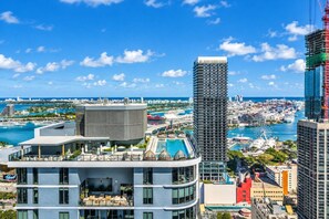 A modern hotel with a rooftop pool and a view of the city skyline and ocean. - LUXURY 1BR/1BA DOWNTOWN APARTMENT (Miami)