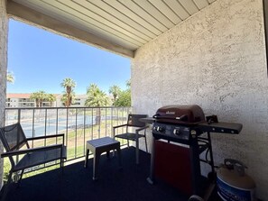 An outdoor patio with a barbecue grill, a table, and chairs. - Las Palmas Resort #1412 | All-Inclusive Amenities (Saint George)