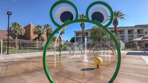 Ein Wasserspielbereich mit Rundformen und einem gelben Ball.