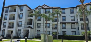 A multi-story residential building with balconies, a staircase, and palm trees. - Modern 3BR VistaCay Apartment Near Disney, Universal & Orlando Attractions Sleeps 7 (Orlando)