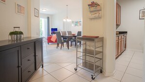 Una cucina moderna con zona pranzo, un lampadario e vista sul soggiorno.