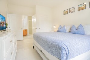 A bedroom with a bed, a dresser, a door, and a wall with pictures. - Modern 3BR VistaCay Apartment Near Disney, Universal & Orlando Attractions Sleeps 7 (Orlando)