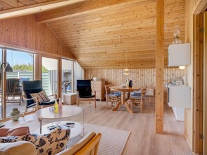 A cozy cabin interior with a dining area, a kitchen, and a seating area with a view. - "Greta" - 300m from the sea by Interhome (Thisted)