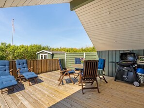 A covered deck with wooden flooring, outdoor furniture, and a barbecue grill. - "Greta" - 300m from the sea by Interhome (Thisted)