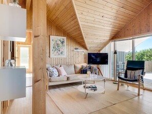 A cozy wooden interior with a sofa, a coffee table, and a TV. - "Greta" - 300m from the sea by Interhome (Thisted)