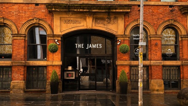 Ein im viktorianischen Stil gestaltetes Gebäude mit dem Schild 'The James', einer Ziegelauffassade und Bogenfenstern.