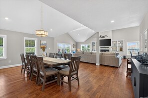 Un'ampia zona giorno con tavolo da pranzo, sedie, divano e televisione.