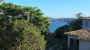 Un quartier résidentiel offrant une vue sur la mer, agrémenté d’une pergola et comprenant une maison avec un toit en tuiles.